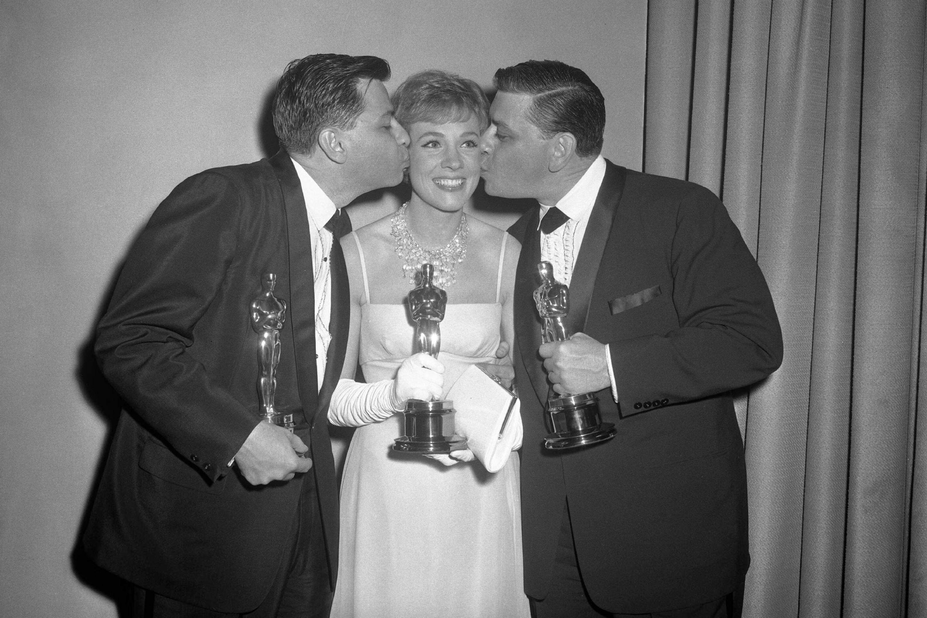 Los compositores Richard y Robert Sherman y la actriz Julie Andrews posan con los Oscar ganados por 'Mary Poppins'
