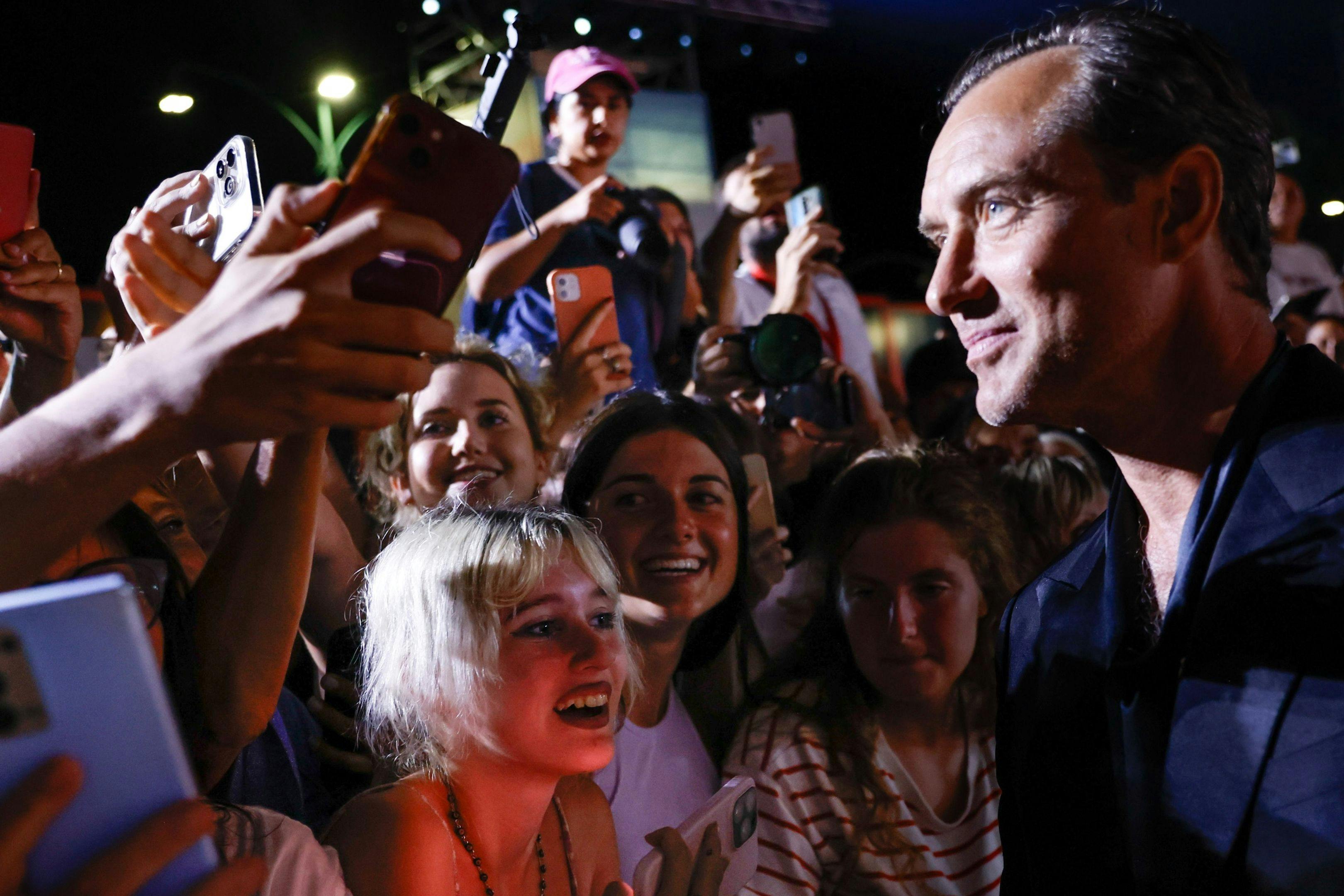 El actor Jude Law saluda a sus fans en la alfombra roja de 'The order' durante la Mostra de Venecia 2024