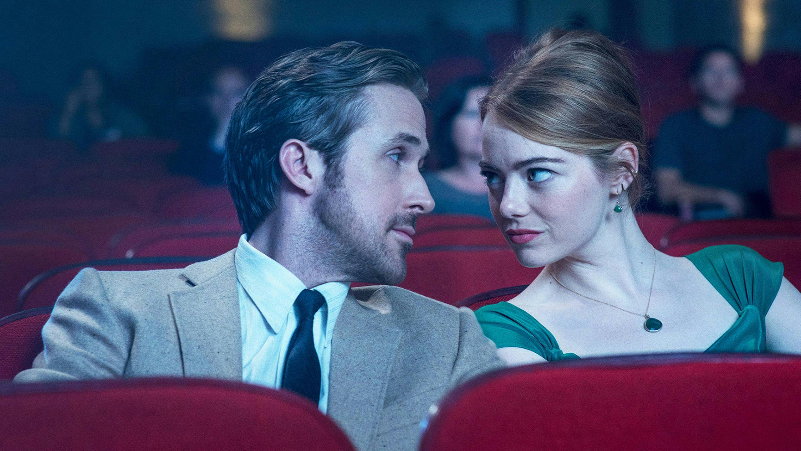 Los actores Ryan Gosling y Emma Stone se miran en el patio de butacas de un cine durante una escena de 'La La Land'