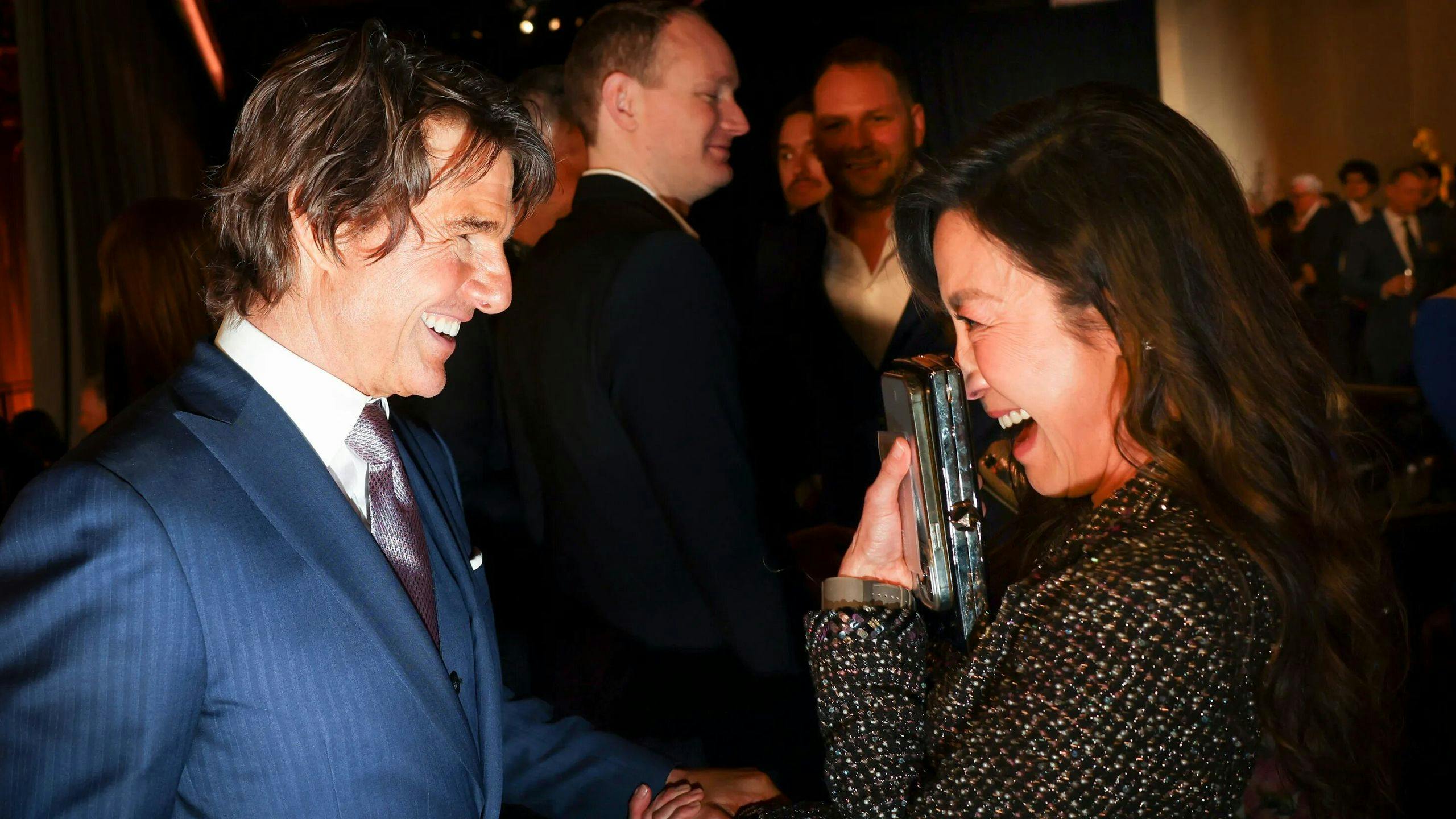 Tom Cruise saluda a Michelle Yeoh durante el almuerzo de nominados de los Oscar 2023