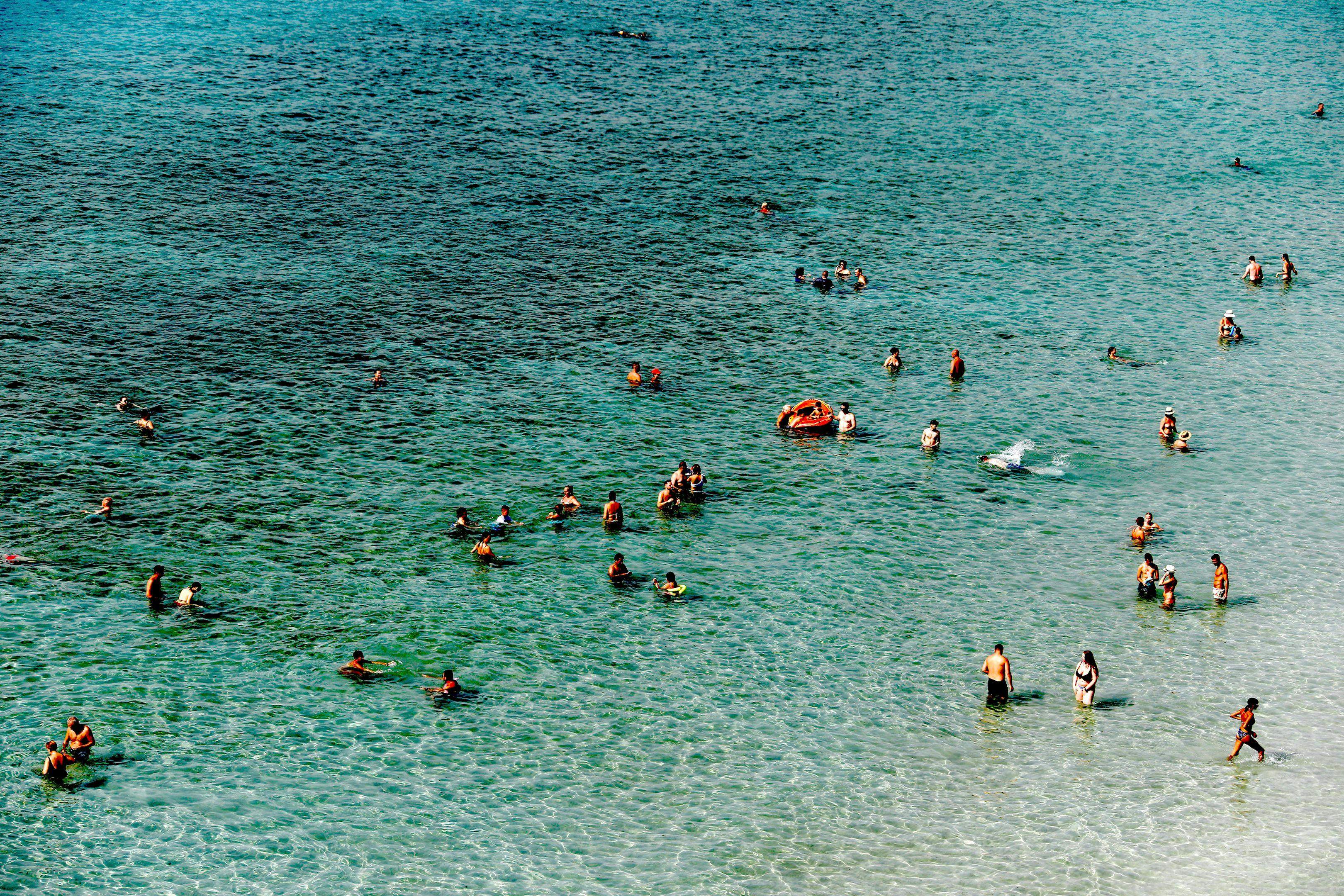 Turistas y locales se bañan, en pleno verano, en una playa de Mallorca