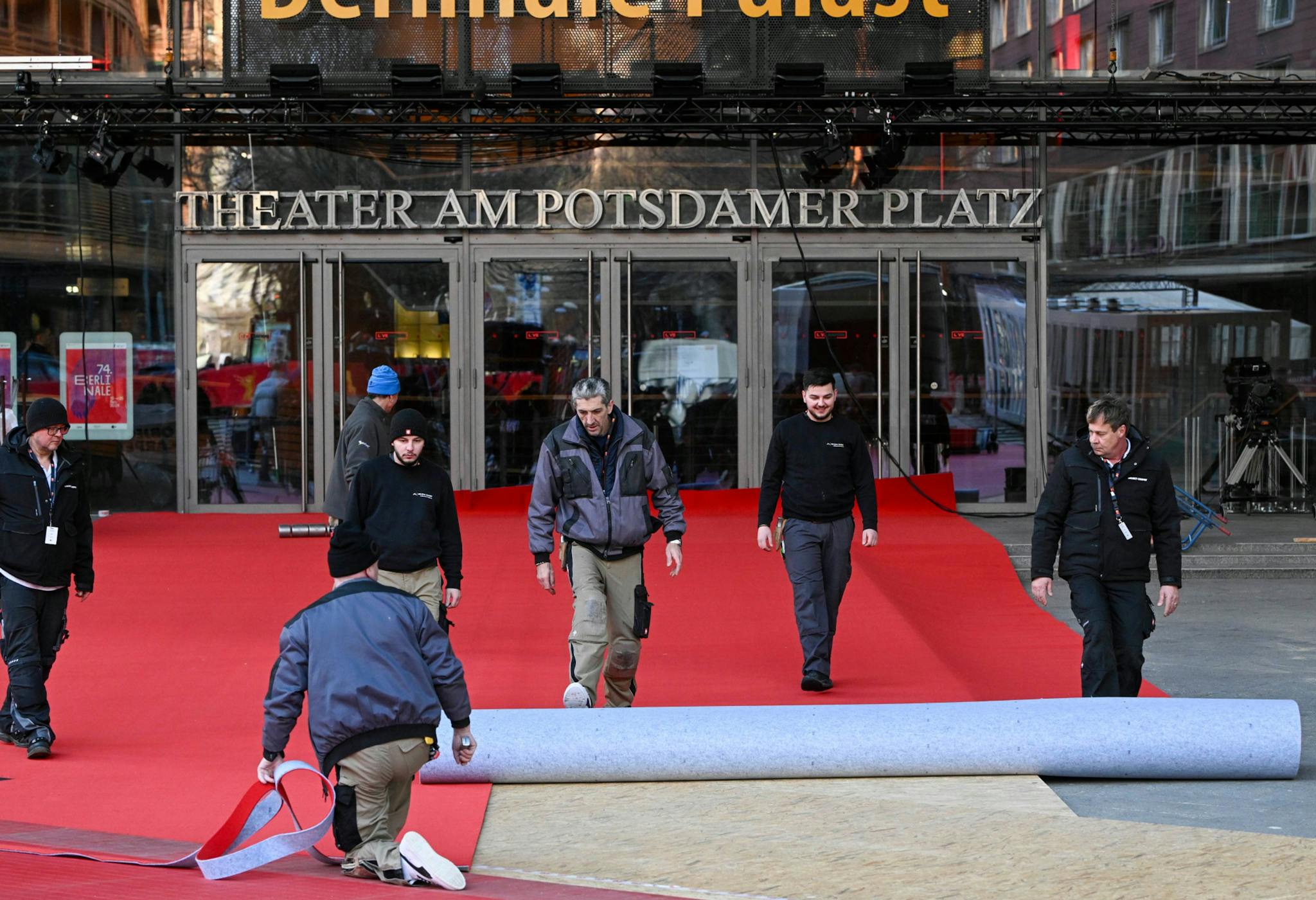 Varios trabajadores del Festival de Berlín desarrollando la alfombra roja a solo dos días de que arranque el certamen 