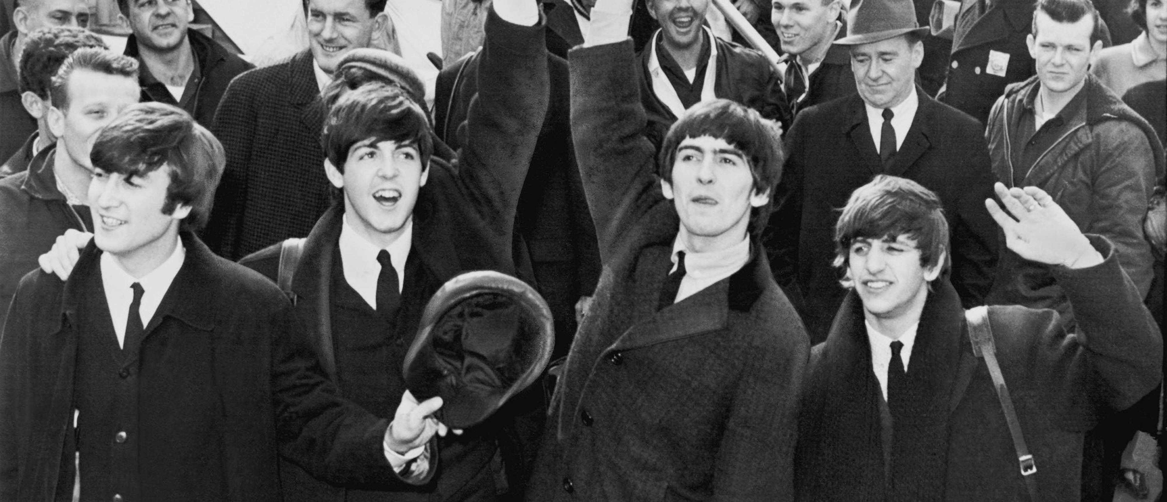 Los cuatro integrantes de 'The Beatles' saludan a sus fans en el aeropuerto Kennedy en 1964