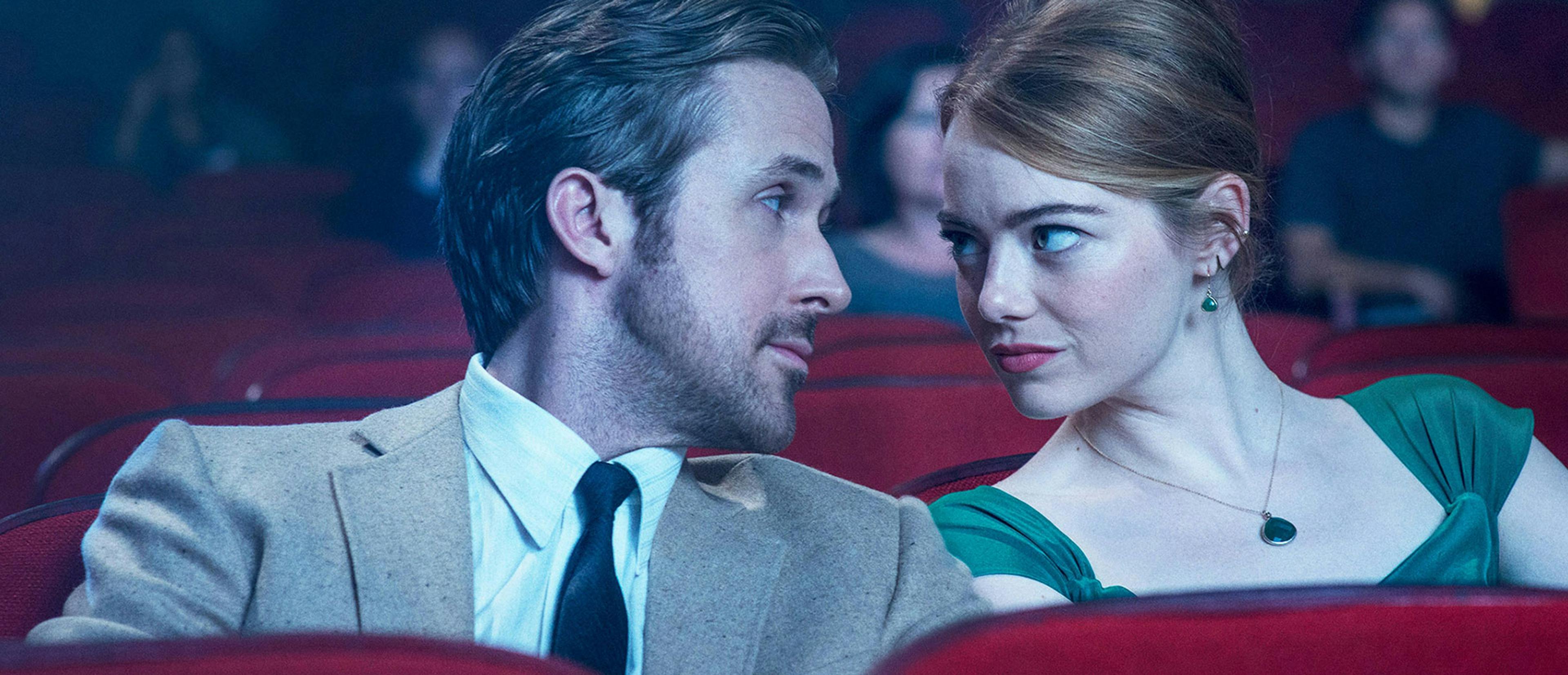 Los actores Ryan Gosling y Emma Stone se miran en el patio de butacas de un cine durante una escena de 'La La Land'