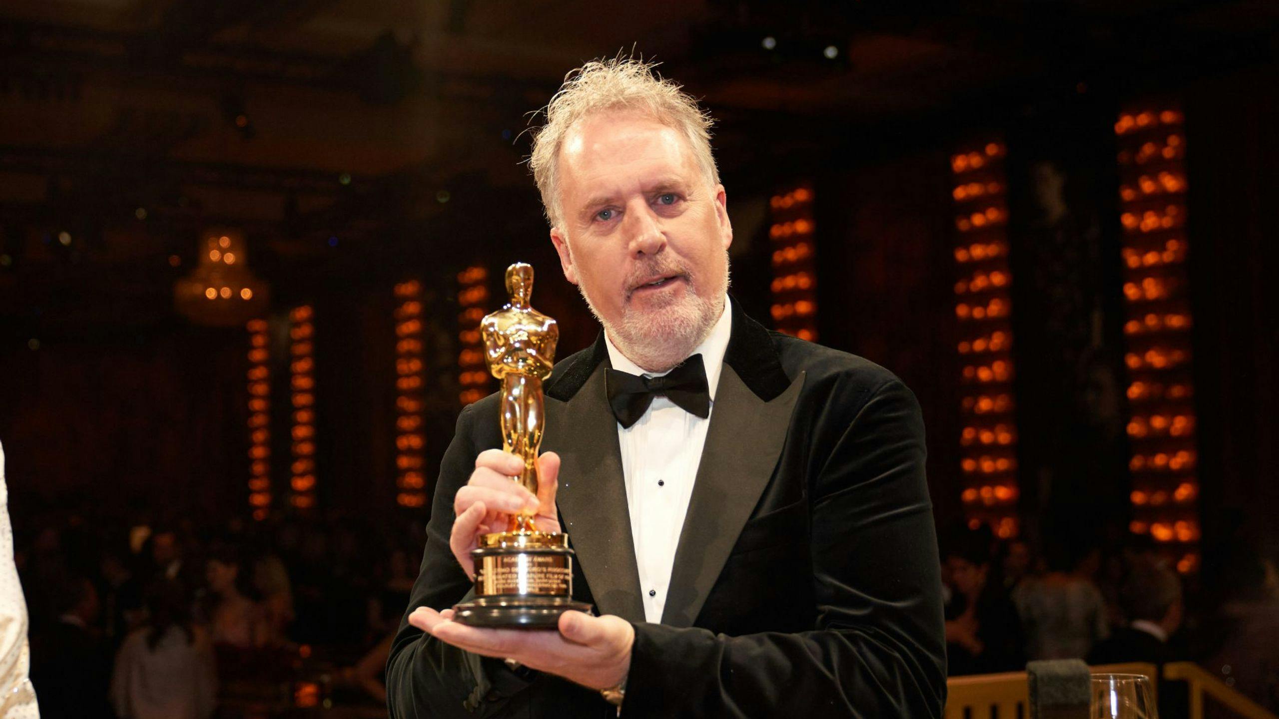 Fotografía del ganador de un Oscar por 'Pinocho' en 2023, Mark Gustafson, posando con su estatuilla 