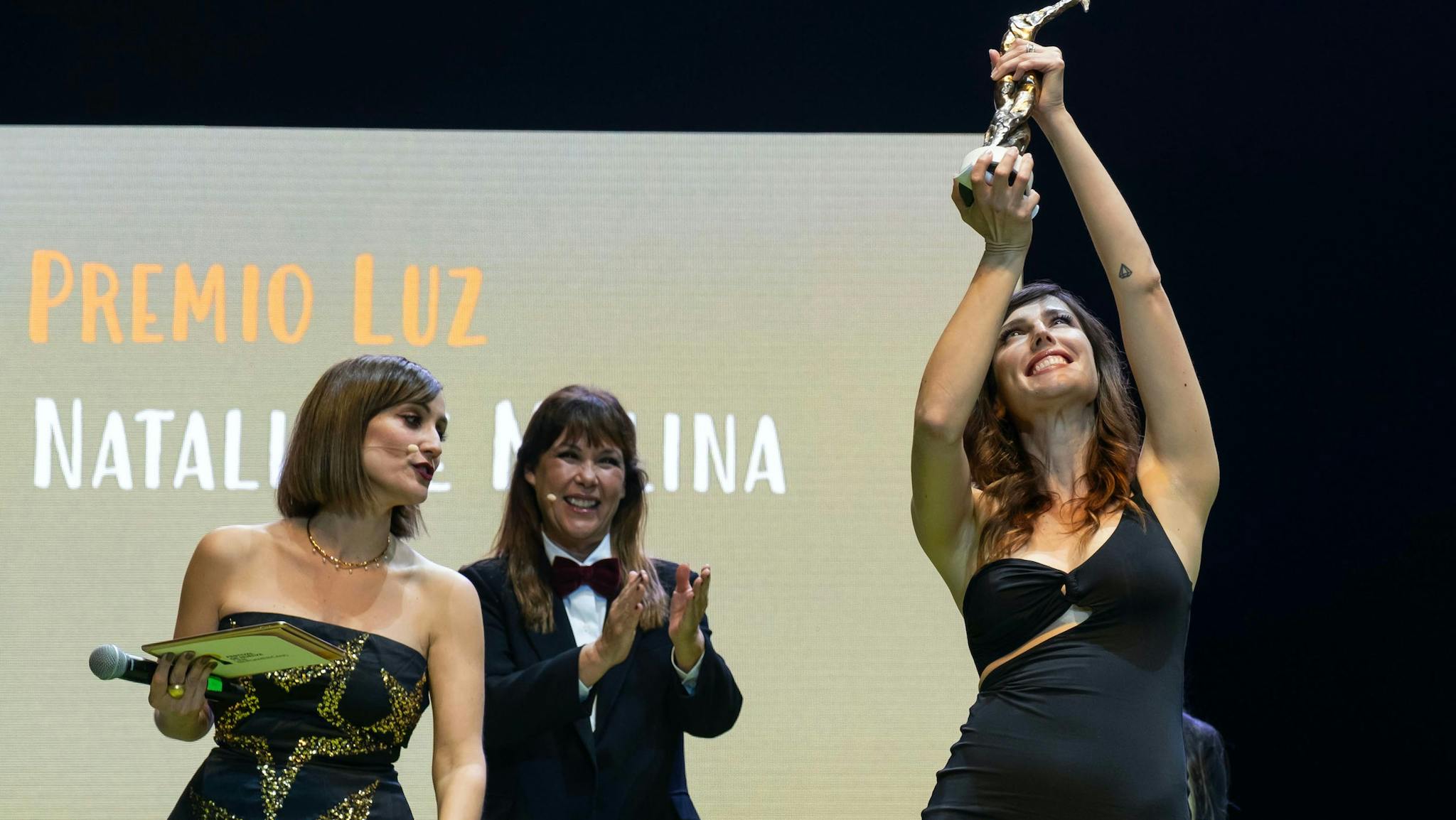 Ana Morgade y Mabel Lozano acompañan a Natalia de Molina, que sostiene su Premio Luz del Festival de Huelva