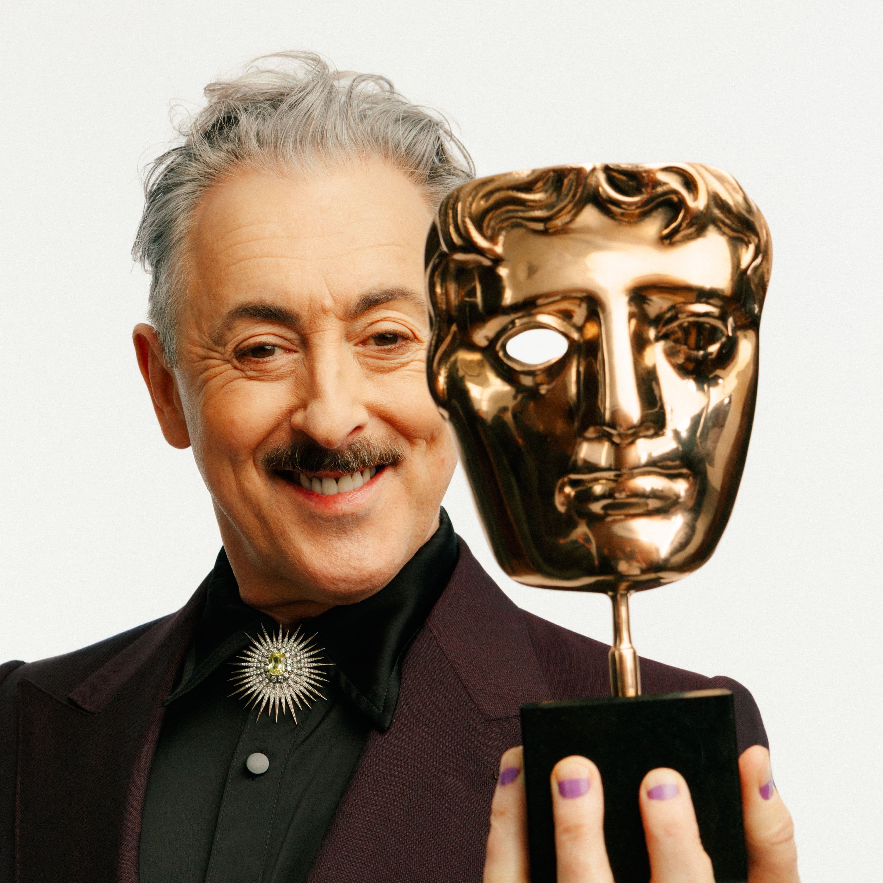 Alan Cumming posa con una estatuilla de los BAFTA