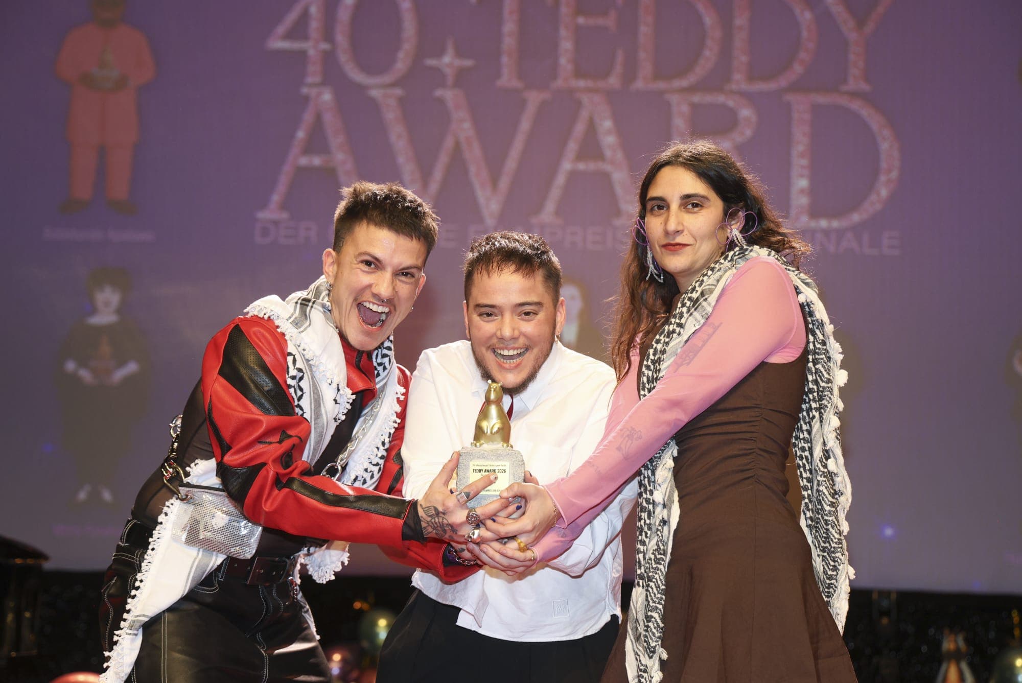 Ian de la Rosa (c) y los actores Silver Chicón (i) y Herminia Loh (d) posan con el Teddy Award 2026 a la Mejor Película para 'Iván & Hadoum'