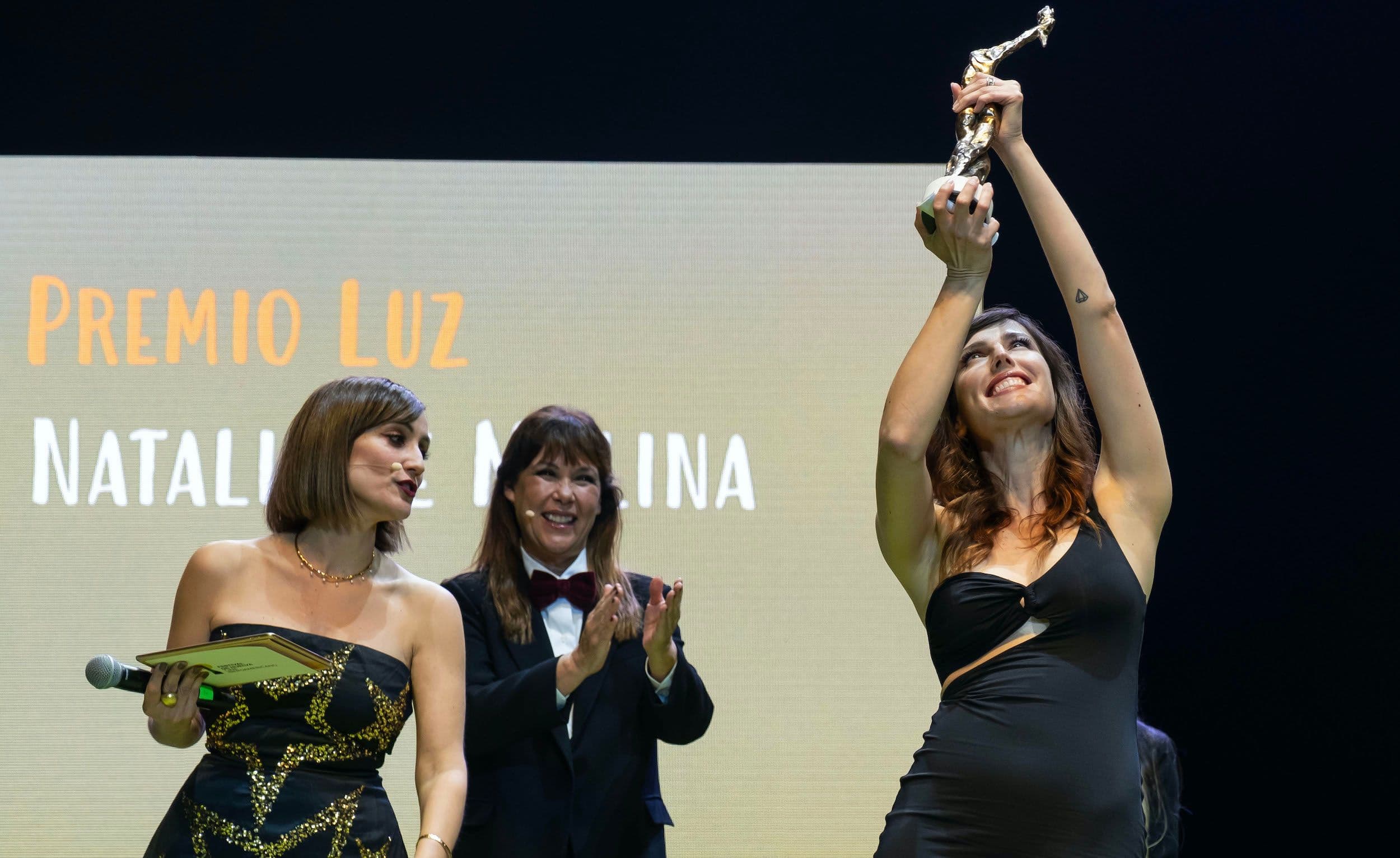 Ana Morgade y Mabel Lozano acompañan a Natalia de Molina, que sostiene su Premio Luz del Festival de Huelva