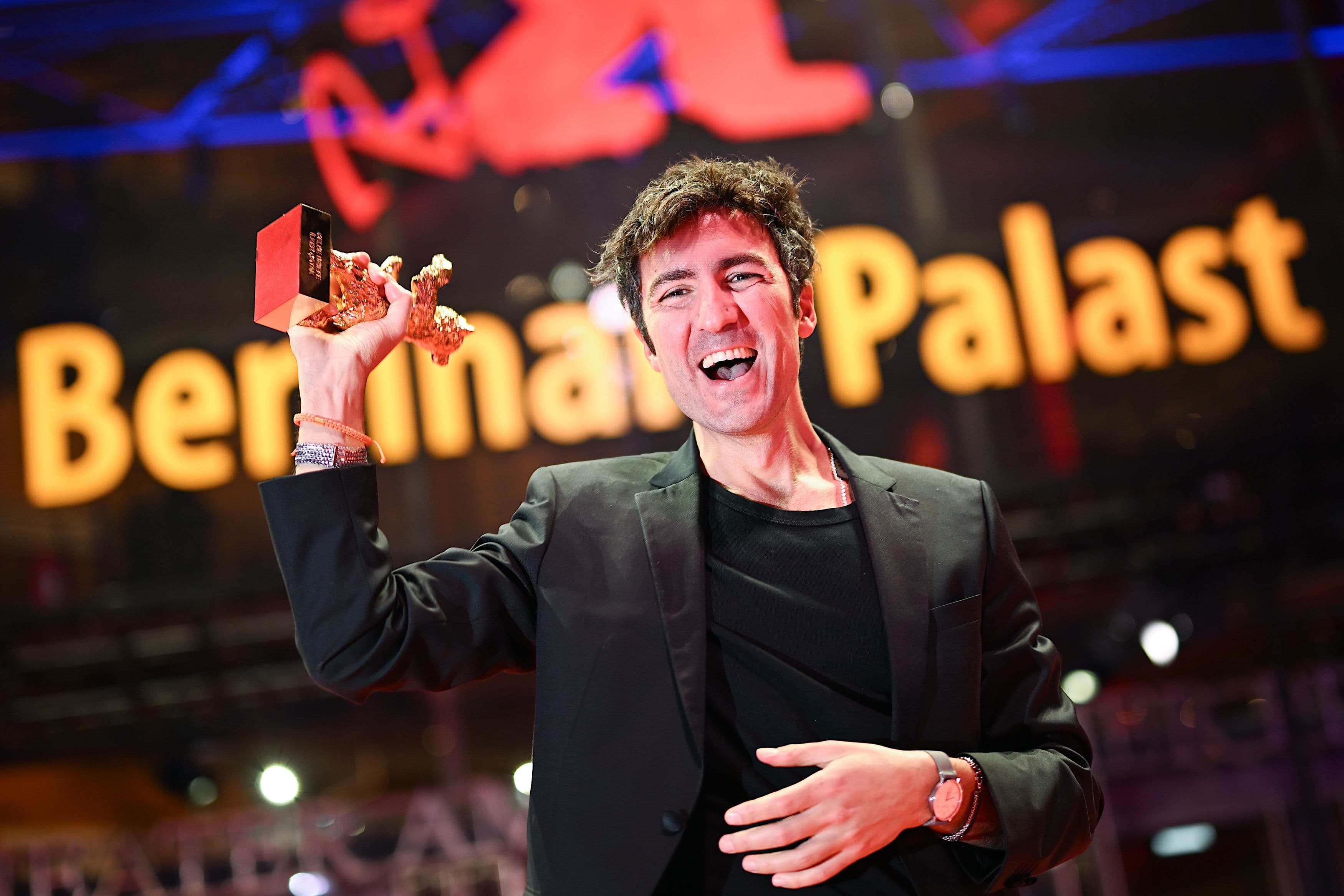 El director Ilker Çatak posa con su Oso de Oro 2026 de la Berlinale para 'Yellow Letter' ante el Berlinale Palast