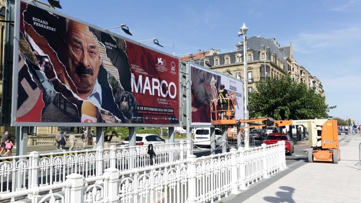 Imagen de ambiente del Festival de San Sebastián 2024, en la que varios operarios colocan los habituales carteles publicitarios