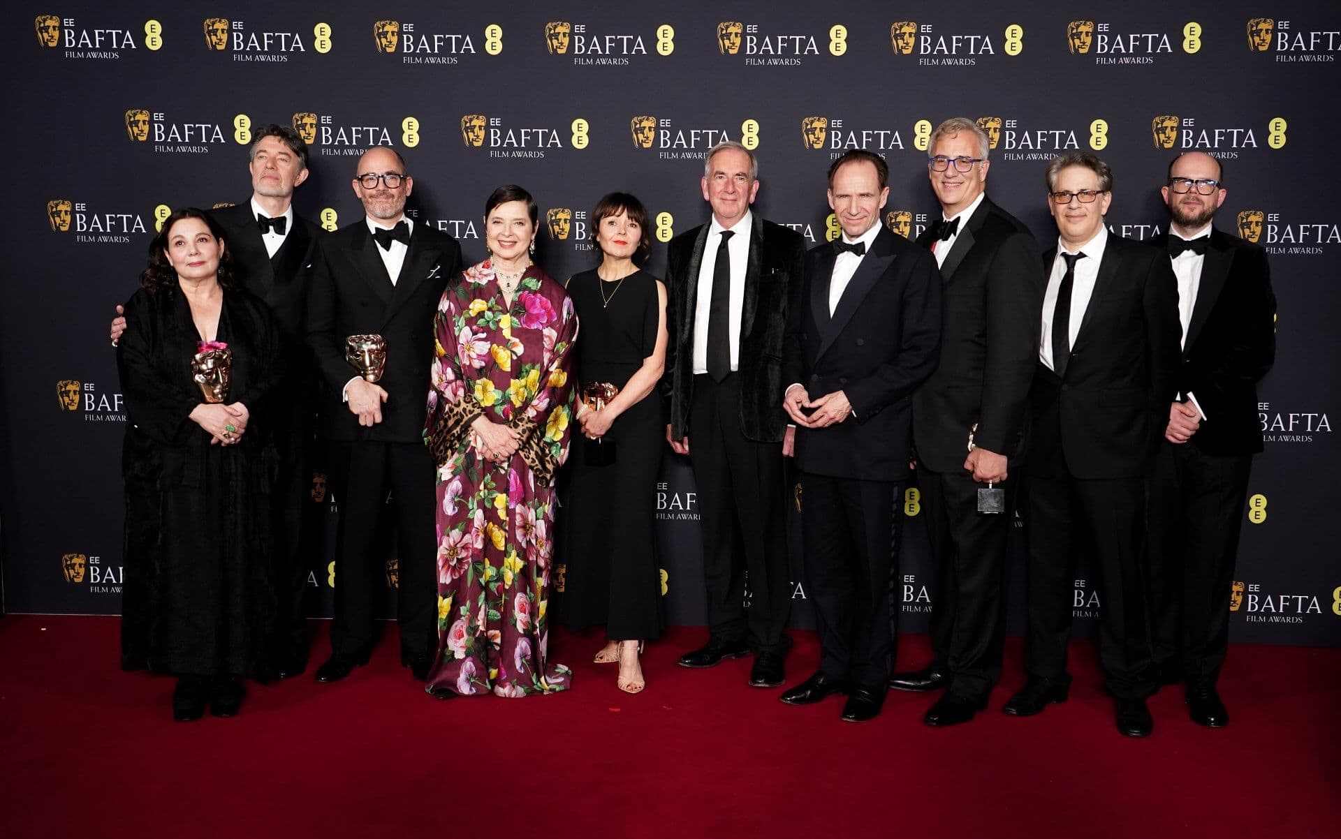 Edward Berger, Isabella Rossellini y Ralph Fiennes, entre otros, posan con los BAFTA que recibió 'Cónclave' en los premios del cine británico