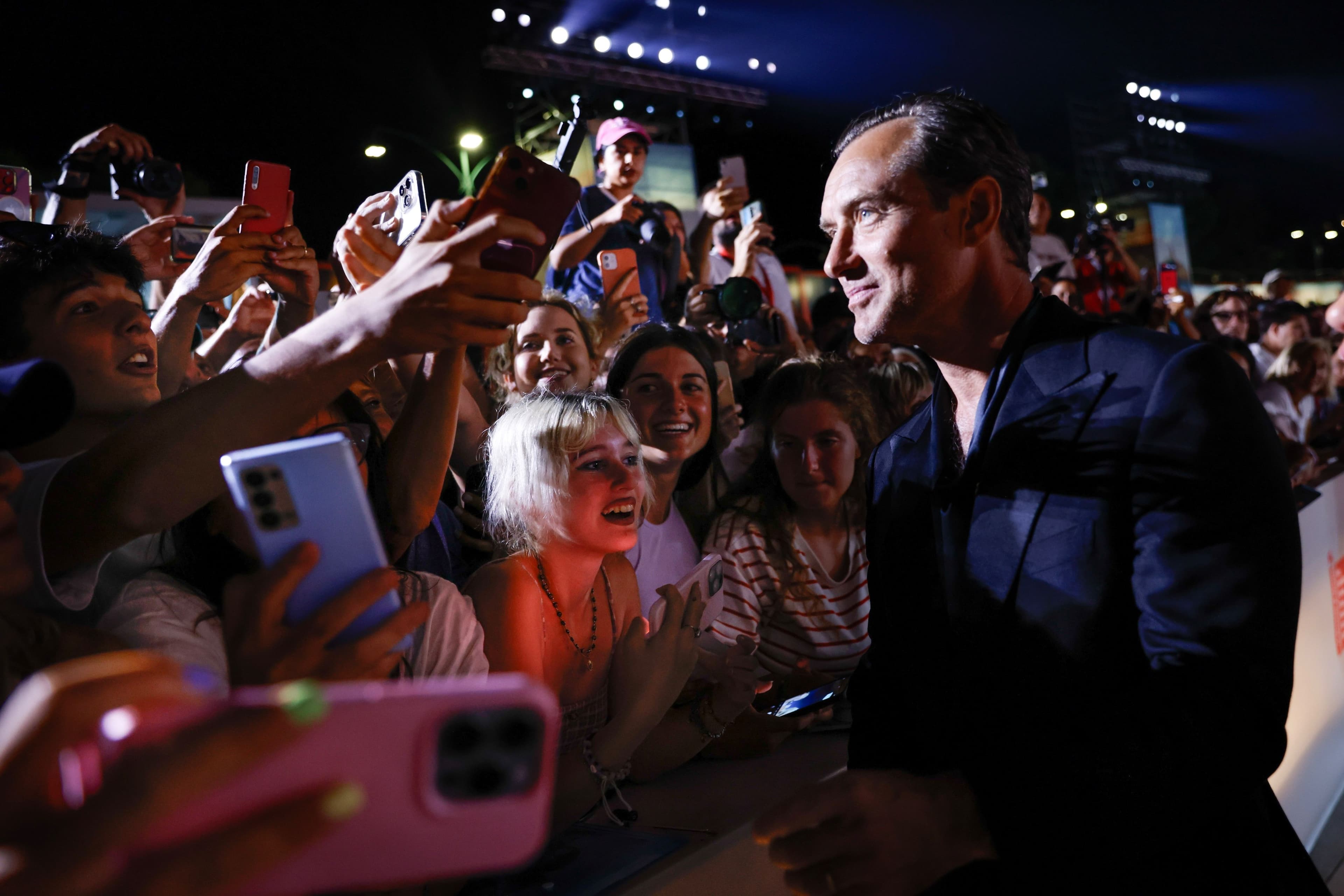 El actor Jude Law saluda a sus fans en la alfombra roja de 'The order' durante la Mostra de Venecia 2024
