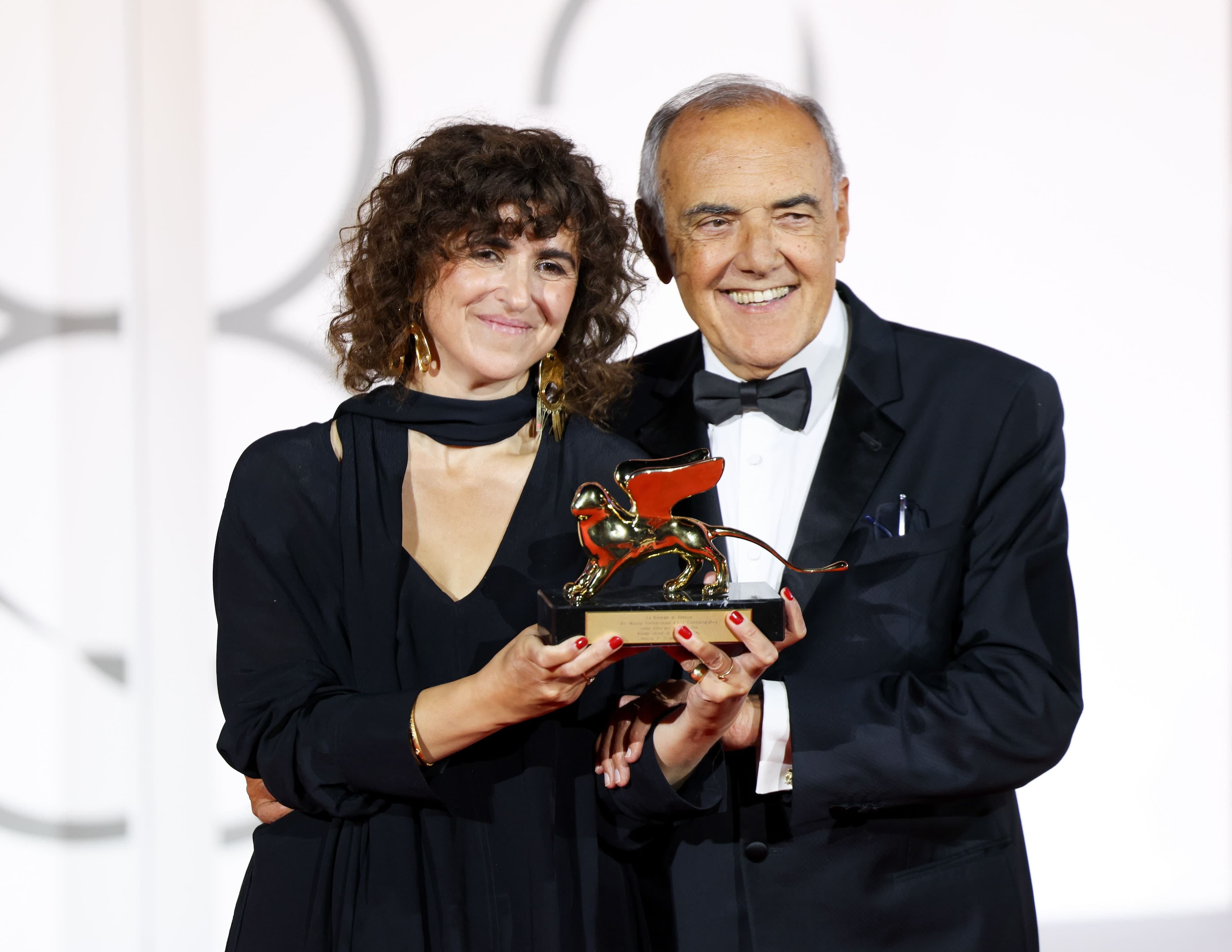 La directora May el-Toukhy posa junto a Alberto Barbera y sostiene el León de Oro para 'Woman Unknown' en el Festival de Venecia 2026