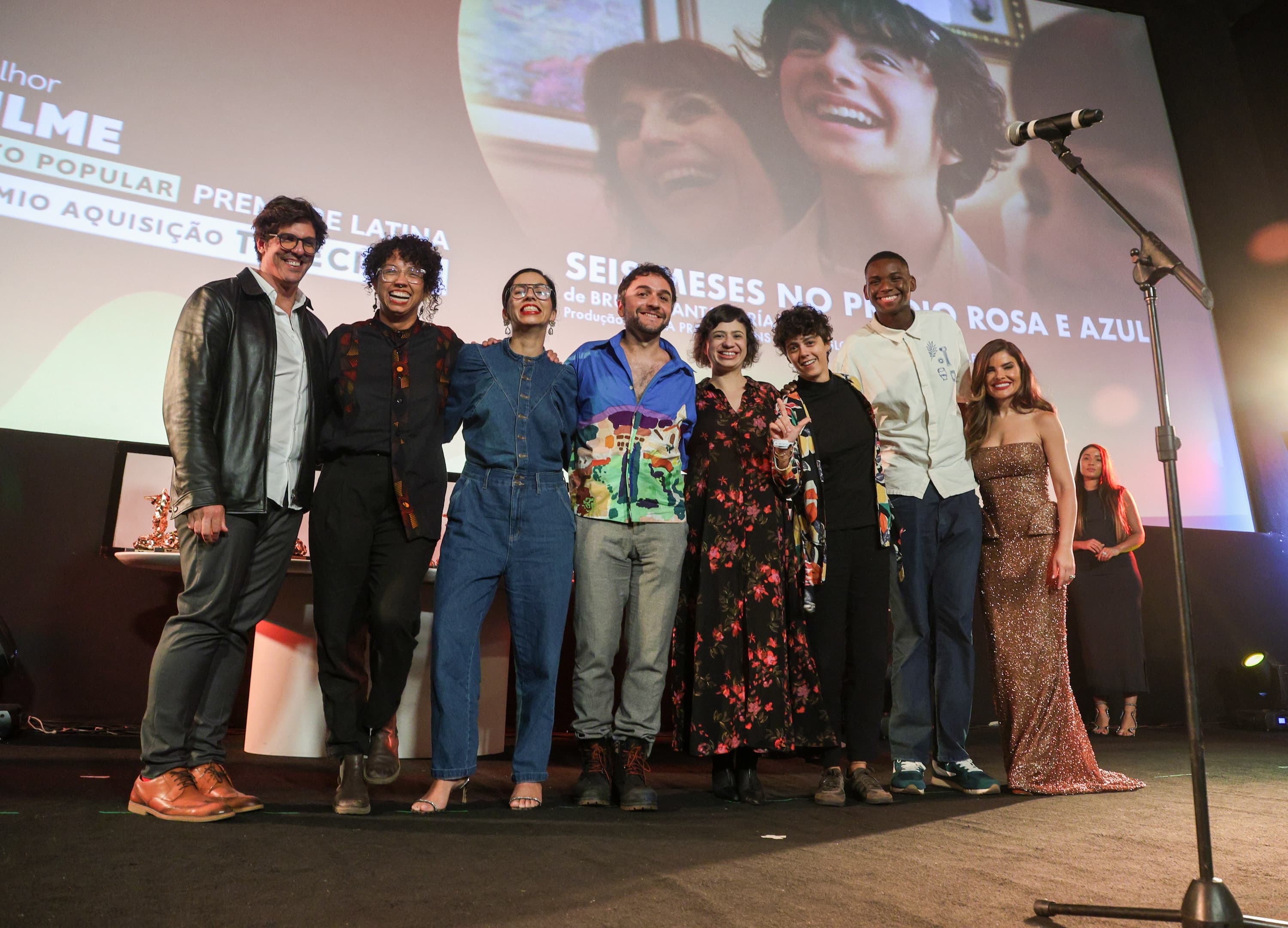 El director Bruno Santamaría Razo y la productora Bruna Haddad (en el centro) reciben uno de sus premios para 'Seis meses en el edificio rosa con azul' en el Festival do Rio 2026